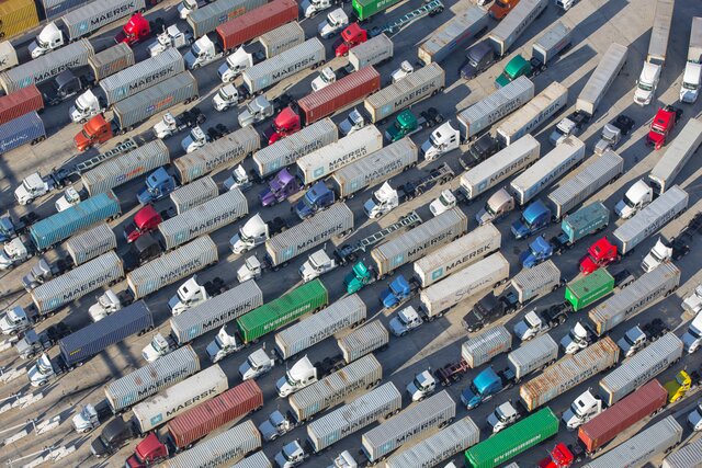 Сотни грузовиков стоят на автостраде в ожидании разгрузки кораблей. Розничный бизнес США ежедневно теряет сотни миллионов долларов